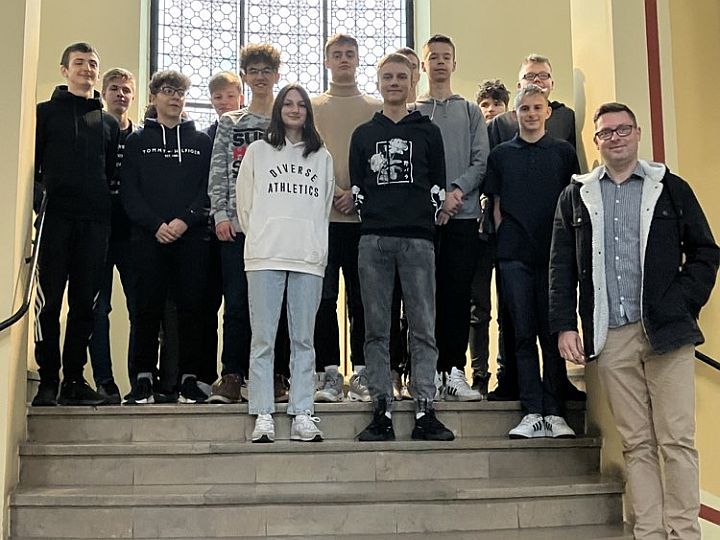 kilkunastoosobowa grupa uczniów wraz z nauczycielem na schodach w budynku Sądu w Gdańsku