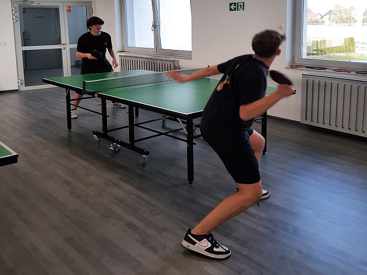 dwoje uczniów podczas gry w tenisa stołowego